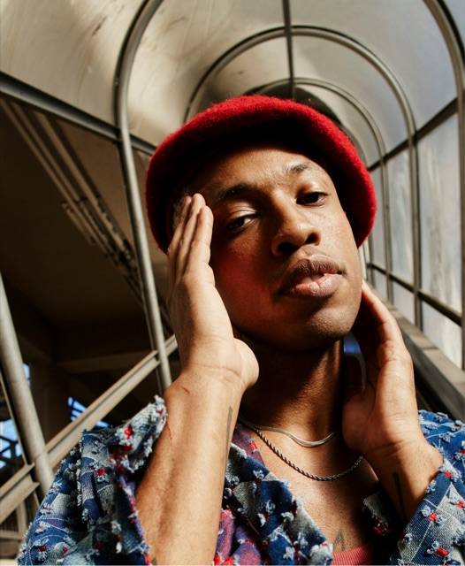 Portrait of a man in a red beanie under a station canopy