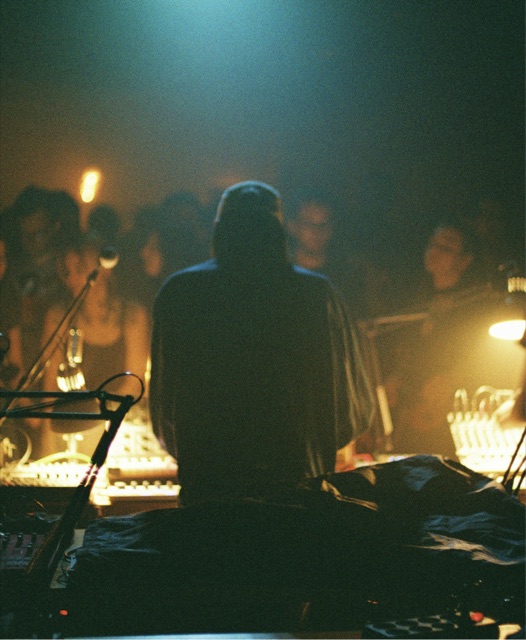 An artist playing to a room in low light